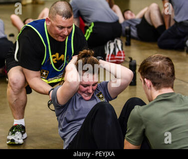 Erste Sgt. Anthony Childs, 1st Battalion, 518Th Infantry Regiment, 98th Abteilung Weiterbildung (IET), hilft ein Infanterist der Zukunft eine Sit-up beim Push-up und Sit-up bohrt mit der Mitte in Asheville, N.C., Jan. 20, 2016. Childs geholfen, die Zukunft Soldaten Programm, in dem fast 40 civillians aus der Gegend, die bereits haben oder beabsichtigen, auf die Anwerbung in die Armee zeigte sich eine Einführung in grundlegende Krieger Aufgaben zu erhalten, bevor Sie auf Basic Combat Training erhalten Sie koordinieren. (U.S. Armee Foto von Sgt. 1. Klasse Brian Hamilton) Stockfoto