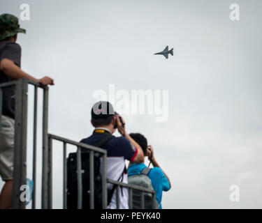 Zuschauer nehmen Sie Bilder als US Air Force F-16C Fighting Falcon von der 35th Fighter Wing, Misawa Air Base, Japan, eine Antenne Demonstration während der Singapore International Airshow führt, am Changi International Airport, Singapore, Jan. 20, 2016. Die Show war eine Gelegenheit für die USA flexible Bekämpfung Fähigkeiten zu zeigen und Gegner abzuschrecken, die gleichzeitig Verbündeten und Partnern. (U.S. Air Force Foto vom Kapitän Raymond Geoffroy/Freigegeben) Stockfoto