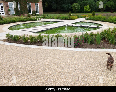 Scharfe sauberer Schnitt Steinplatten und verschiedene formelle Wege & dekorative Teich mit gepflasterten Bereich auf ein Land Haus Garten in England Eigentum freigegeben Stockfoto