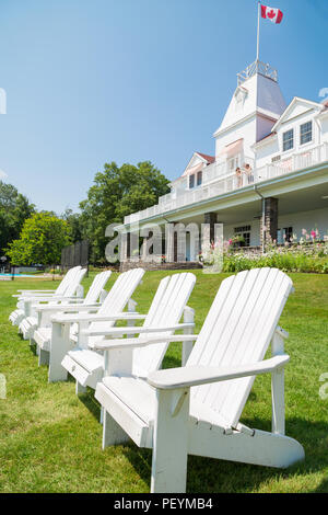 WINDERMERE, ON, Kanada - 21. JULI 2017: Eine Reihe von Muskoka Stühlen sitzen auf der Wiese vor dem historischen Windermere House am Lake Rosseau, Ontario. Stockfoto