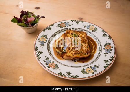 Eine Platte der timballo Pasta mit einem Beilagensalat. Stockfoto