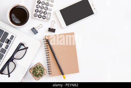 Weiß Büro Schreibtisch Tisch, Arbeitsbereich Büro mit Laptop, Smartphone schwarzer Bildschirm, Kaffeebecher, Kugelschreiber, Taschenrechner, Gläser, Ansicht von oben mit der Kopie Raum Stockfoto