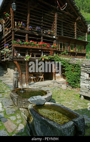 Dorf Wold mit alten Walser Haus andstone Brunnen in der Nähe der Stadt Alagna, Verbania, Piemont, Italien Stockfoto