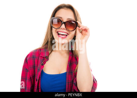 Hübsche junge Teenager Frau in kariertem Hemd tragen Trendy Sonnenbrille an Kamera lächelnd isoliert auf weißem Hintergrund Stockfoto