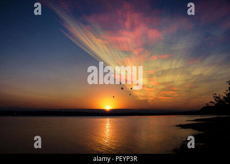 Bunte und bewölkter Sonnenuntergang in den See in Villa Carlos Paz, Cordoba, Argentinien Stockfoto