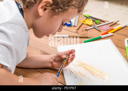 Konzept der zurück in die Schule. Kind schärfen einen Bleistift auf Holzplatten. Stockfoto