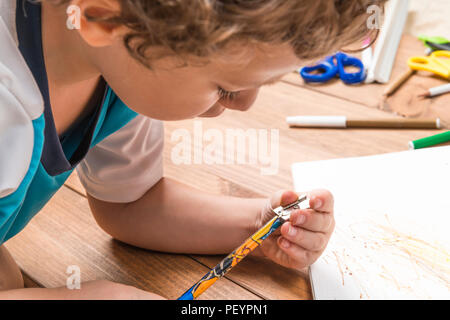 Konzept der zurück in die Schule. Kind schärfen einen Bleistift auf Holzplatten. Stockfoto