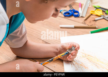 Konzept der zurück in die Schule. Kind schärfen einen Bleistift auf Holzplatten. Stockfoto