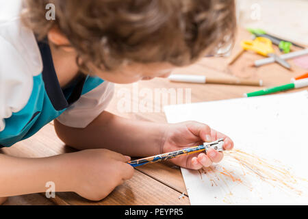 Konzept der zurück in die Schule. Kind schärfen einen Bleistift auf Holzplatten. Stockfoto