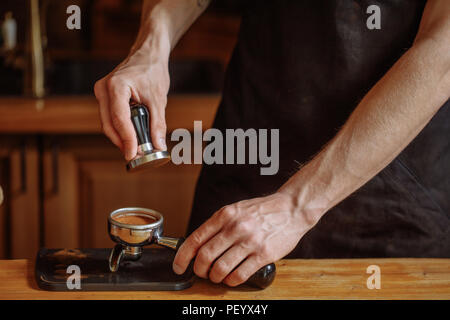 Ein Barista ist mit einem Stampfer zu drücken/seads. Nahaufnahme 7/8 Shot Stockfoto