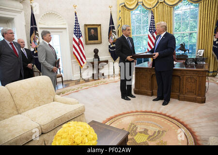 Präsident Donald J. Trumpf ist eine US-Flagge von Kelly McKeague, Direktor des Verteidigungsministeriums POW/MIA accounting Agentur, Dienstag, 12.08.14, 2018, im Oval Office vorgestellt. McKeague und Kolleginnen und Kollegen des DOD POW/MIA Accounting Team aktualisiert der Präsident auf der Identifikation von bleibt zurück durch Nordkorea der fehlenden US-Truppen während des koreanischen Krieges getötet. Personen: Präsident Donald Trump Stockfoto