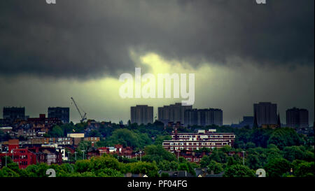 Glasgow, Schottland, Großbritannien. 18 August, 2018. UK Wetter: Schwarz und Grau Himmel als Sturm Ernesto liegt über der Stadt, wie über Nacht Regen ist durch den Tag prognostiziert. Keine sky Farbe mit einem Sinn für Perspektive kommt aus Gebäude der Stadt wie die Sonne nicht, um den Overhead zu erscheinen. Die grünen Randbezirke des West End mit der imposanten Roten zugemauert Vordergrund art deco Kelvin Gericht von den Türmen des Stadtgebiets und die Stadt 2 Meilen weiter weg Gerard Fähre / Alamy news Kredit übersehen: Gerard Fähre / alamy Leben Nachrichten Stockfoto