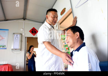 Peking, China. 18. August 2018. Arzt Yu Jiajun behandelt einen Patienten in Qishan Dorf Mabu Township, Jinzhai County in der ostchinesischen Provinz Anhui, Sept. 14, 2017. China wird seine erste medizinische Arbeiter' Day am 12.08.19, 2018 Mark. (Xinhua / Liu Junxi) (lmm) (ZT) Quelle: Xinhua/Alamy leben Nachrichten Stockfoto