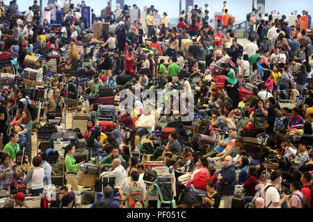 Paranaque City, Philippinen. 18 Aug, 2018. Eine Masse von gestrandeten Passagiere warten auf Wiederaufnahme der Flüge am Ninoy Aquino International Airport (NAIA) in Paranaque City, Philippinen, Nov. 18, 2018. Die philippinischen Flughafen Behörden am Samstag seine wichtigsten Start- und Landebahn des internationalen Flughafens von Manila wieder eröffnet, nachdem der Ausbau des stark beschädigten Xiamen eine Passagiermaschine, die Rutschte die Start- und Landebahn am Donnerstag. Credit: rouelle Umali/Xinhua/Alamy leben Nachrichten Stockfoto