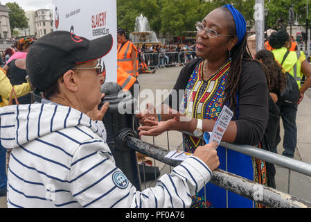 London, Großbritannien. 18. August 2018. Frauen sprechen miteinander bei der jährlichen Nationalen Gedenkfeier auf dem Trafalgar Square erinnert und ehrt die Opfer des afrikanischen Holocaust/transatlantischen Sklavenhandel und Sklaverei gefördert Internationaler Tag der Erinnerung, 23.August. Die Veranstaltung namens für die Afrikaner ihre Identität zu feiern und ihre Vorfahren zu erinnern, und begann mit Drinks erinnern viele schwarze Helden. Ers über die Diskriminierung in der Gutschrift gesprochen: Peter Marschall/Alamy leben Nachrichten Stockfoto