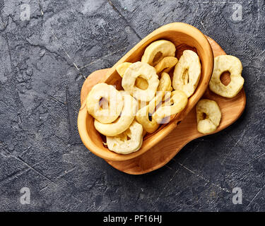 Getrocknete Apfel Ringe auf schwarzem Hintergrund. Ansicht von oben. Stockfoto