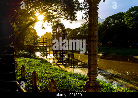 Sonnenuntergang über den Fluss in der Stadt Siem Reap mit der Sonne tief über das Wasser Rad scheint. Stockfoto