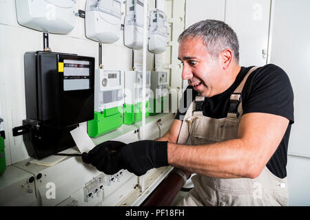 Lustige Elektriker tun Elektrische Reparatur Stromzähler Stockfoto