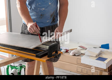 Der fliesenleger Maßnahmen und setzt Marken zu reduzieren und ein Fliesen legen. Home Renovierung. Stockfoto