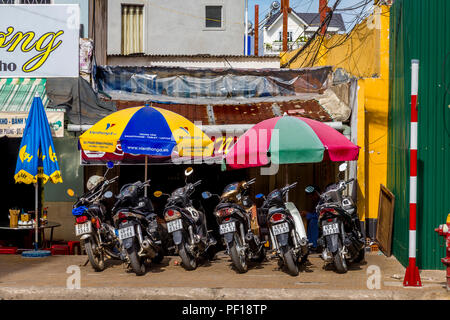 Motorräder vor einem Cafe unter bunten Sonnenschirmen geparkt in Dalat Stockfoto