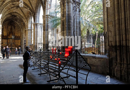 Eine Frau steht an einer Kerze Rack Im Klostergarten, der Kathedrale von Barcelona Spanien Stockfoto