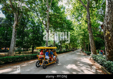 Sevilla, Spanien - 15. Juli 2018: Die Familie fährt auf einer Radtour Fahrrad auf einem Pfad im Maria Luisa Park im Sommer Stockfoto