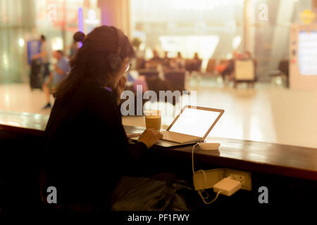 Touristische Frau Arbeiten am Laptop mit Kopfhörer in einem Coffee Shop Stockfoto