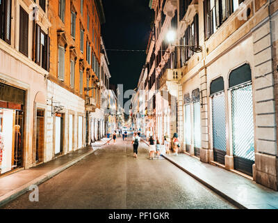 Typische italienische Straße bei Nacht im Zentrum der Altstadt. Rom, Italien. Menge beleuchteten Boutiquen und Geschäften. Stockfoto