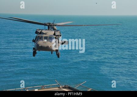 Oklahoma Army National Guard Soldaten zu Unternehmen B zugewiesen sind, 1.BATAILLON, 140 Aviation Regiment, Task Force Longknife, 40th Combat Aviation Brigade, Durchführung deck Qualifikation Landungen auf die usns Alan Shepard in der UH-60 Black Hawk Hubschrauber über dem Arabischen Golf Feb 16. Um sich zu qualifizieren und erfahrene Besatzungen, bleiben die anspruchsvolle Aufgabe, zu der die Landung auf einem fahrenden Schiff mehrfach durchgeführt. (U.S. Armee Foto von SPC. Rose Wolford, 40th Combat Aviation Brigade Public Affairs) Stockfoto