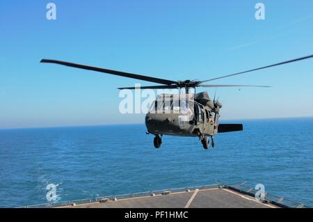 Oklahoma Army National Guard Soldaten zu Unternehmen B zugewiesen sind, 1.BATAILLON, 140 Aviation Regiment, Task Force Longknife, 40th Combat Aviation Brigade, Durchführung deck Qualifikation Landungen auf die usns Alan Shepard in der UH-60 Black Hawk Hubschrauber über dem Arabischen Golf Feb 16. Um sich zu qualifizieren und erfahrene Besatzungen, bleiben die anspruchsvolle Aufgabe, zu der die Landung auf einem fahrenden Schiff mehrfach durchgeführt. (U.S. Armee Foto von SPC. Rose Wolford, 40th Combat Aviation Brigade Public Affairs) Stockfoto