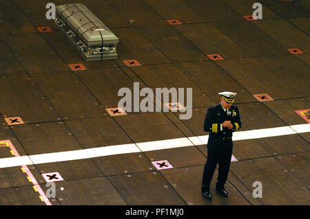 Am 24. Januar 2016, an Bord des amphibischen Angriffsschiffs USS Makin Island (LHD 8) im Pazifik, spricht der Kommandant der Besatzung während einer Zeremonie zur Beerdigung auf See auf dem Brunnendeck für einen ehemaligen Schiffskameraden an. Das Schiff führt Seetests vom Typ Commander durch, testet Antriebs-, Navigations-, Kommunikationssysteme und operative Fähigkeiten, während zeremonielle Traditionen beibehalten und Personal geehrt werden. Stockfoto