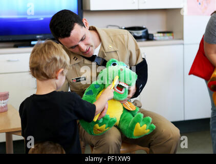 Leutnant Matthew Jurcak, ein Zahnarzt mit 1 zahnmedizinische Bataillon, 1. Marine Logistics Group, lehrt ein Junge im San Onofre Child Development Center die richtige Art und Weise seine Zähne als Teil einer zahnmedizinischen Gesundheit Outreach Programm an Bord Camp Pendleton, Calif., Feb 23, 2016 zu bürsten. Zahnmedizinische Bn. hat schon zu schulen und Kinderzentren rund um Camp Pendleton im Laufe des Monats Februar für zahnmedizinische Gesundheit der Kinder Monat gute Mundhygienegewohnheiten zu lehren und zahnmedizinische Gesundheit fördern. (U.S. Marine Corps Foto von Cpl. Carson Gramley/freigegeben) Stockfoto