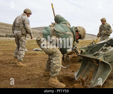 Canon Besatzungsmitglied mit 1St Battalion, 37th Field Artillery Regiment, 2. Abteilung Artillerie, 7 Infanterie Division, Joint Base Lewis-McChord, Washington, gräbt ein Graben für den Fuß eines M777 Haubitze während einer Schulungsveranstaltung in Yakima Training Center, Yakima, Washington, 24.02.24. Canon Crew Mitglieder haben ca. 30 Sekunden der M 777, bevor die Haubitze in Betrieb zu stabilisieren. (U.S. Armee Foto von Sgt. Cody Quinn/28 Public Affairs Abteilung) Stockfoto