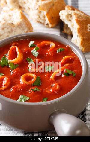 Italienische Küche würzige Tintenfische in Tomatensauce close-up in eine Schüssel. Vertikale Stockfoto