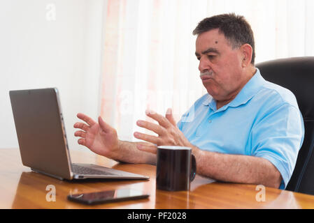 Wütend älterer Mann Arbeiten am Laptop. Negative Emotion. Stockfoto