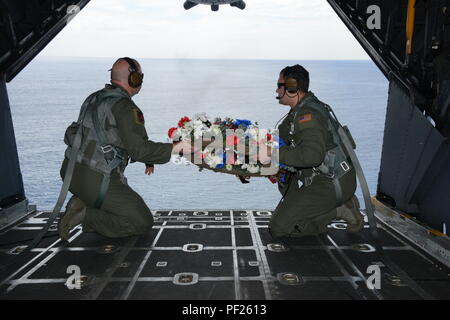 Von links, Tech. Sgt. Brett Bollinger und Tech. Sgt. Michael Gillette, beide loadmasters am 1. Special Operations Squadron bereiten einen Kranz aus einem MC-130H Combat Talon II vor der Küste der Philippinen Feb.26, 2016 in Erinnerung an diejenigen, die bei dem Absturz von Streunenden 59 gestorben. Der Flug ehrt die, die vor 35 Jahren verloren gegangen waren, als ein 1. SOS-MC-130E, Rufzeichen STRAY 59, während einer Übung töten acht Besatzungsmitgliedern und 15 Passagieren abgestürzt. (U.S. Air Force Foto von Master Sgt. Kristine Dreyer, 353 SOG PA/Freigegeben) Stockfoto