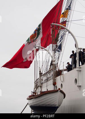 Eine peruanische Flagge über ein Leben, das Boot am Heck des BAP Union Segelschiff aus Peru winken günstig auf das Dock während der "nautischen Velas Latinoamerica 2018" Veranstaltung, die in Lima Peru stattfindet. Die Veranstaltung versammelt 8 Schulung Segelschiffe aus lateinamerikanischen Ländern. Stockfoto