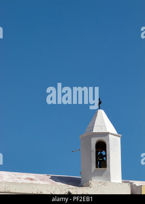 Kalabrien (Italien): Kleine weiße Glockenturm auf dem Dach einer Kirche, mit den blauen, wolkenlosen Himmel im Hintergrund, in einem sonnigen Sommertag Stockfoto