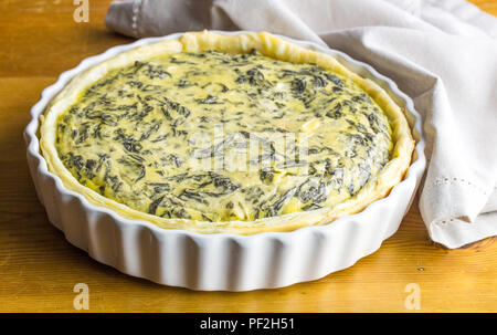 Spinat Tarte mit Eiern und Feta auf hölzernen Tischplatte Stockfoto