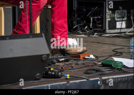 Ein blues Fuß in Cowboystiefeln Taps aus dem Rhythmus auf eine verstärkte Stomp Box an einem Open Air Festival an einem heißen Tag in London. Stockfoto