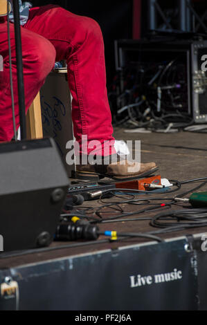 Ein blues Fuß in Cowboystiefeln Taps aus dem Rhythmus auf eine verstärkte Stomp Box an einem Open Air Festival an einem heißen Tag in London. Stockfoto