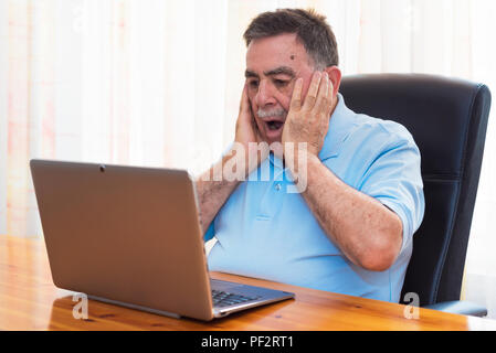 Ältere Menschen arbeiten mit Laptop überrascht. Stockfoto