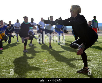 Ein Trainer auf der Nellis Air Force Base, Nevada, demonstriert den Airmen nach dem Warrior Trained Fitness-Event am 25. Januar 2016 auf der Creech Air Force Base Stretching-Techniken. Als Teil der Kampagne „Leben eines Kriegers“ fördert das Programm die spirituelle, soziale, mentale und körperliche Belastbarkeit, indem es Airmen ermutigt, zu interagieren, sich an Fitnessaktivitäten zu beteiligen und an Freundschaftswettbewerben teilzunehmen, um die allgemeine Bereitschaft und das Wohlbefinden zu verbessern. Stockfoto