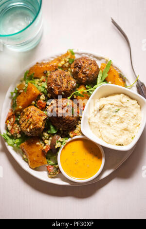 Felafels mit Bulgur, Rakete, Blätter, butternut Kürbis Salat & Stil Houmous & tahini Zitrone Dressing Stockfoto