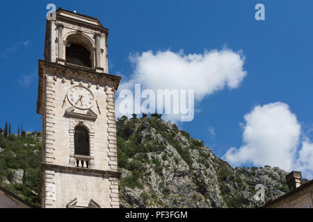 Blick auf oberen Teil der Steinernen Glocke/Clock Tower am Sankt-tryphon Kathedrale in Kotor, Montenegro mit Hügel/Berge im Hintergrund an einem sonnigen Tag. Stockfoto
