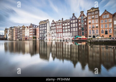 Am Abend Blick auf die 'Dancing Häuser der Damrak, iconic canal Häuser in der Hauptstadt Amsterdam. Stockfoto