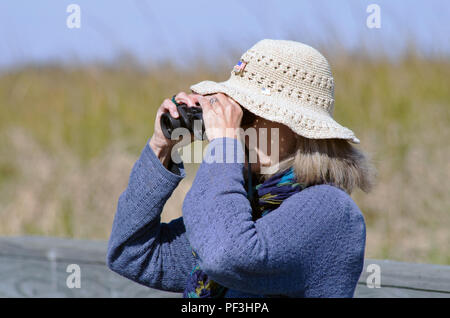 Eine Frau, die mit dem Fernglas views Wildlife am zum Beispiel: Leonabelle Turnbull Birding Center in Port Aransas, Texas USA. Dieser Standort ist in der Nähe von Corpus Christi. Stockfoto