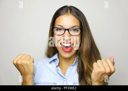 Happy entschlossene junge Frau mit erhobenen Händen schreien und Erfolge feiern auf weißem Hintergrund Stockfoto