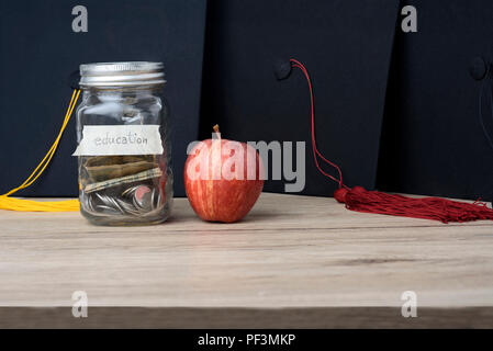 Geld in einem Glas auf dem Tisch für ein Studium, Promotion Konzept. Stockfoto