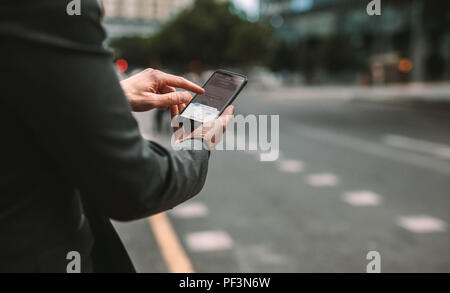 Online Mitfahrzentrale und Mitfahrgelegenheit mobile Anwendung. Rideshare taxi App auf dem Smartphone angezeigt. Männliche Pendler mit online-Transport Service. Stockfoto